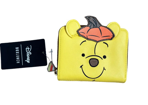 A yellow Disney Winnie the Pooh character zip wallet with a pumpkin on top.